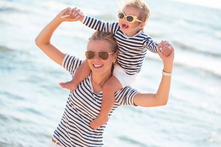 Mother playing with daughter on the beachの写真素材