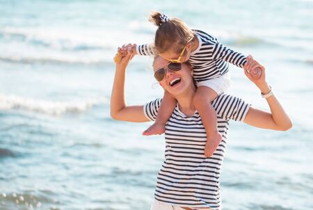 Mother playing with daughter on the beachの写真素材