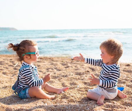 Little boy and girl playing on the beachの写真素材
