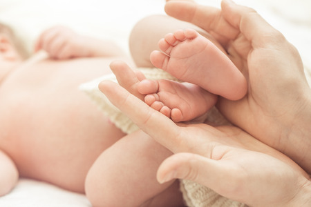 Baby feet in mother handsの写真素材