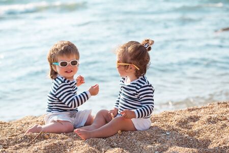 Little boy and girl playing on the beachの写真素材