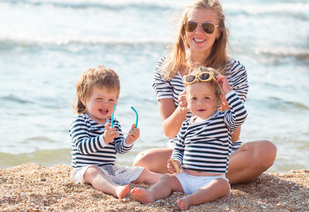 Mother playing with children on the beachの写真素材