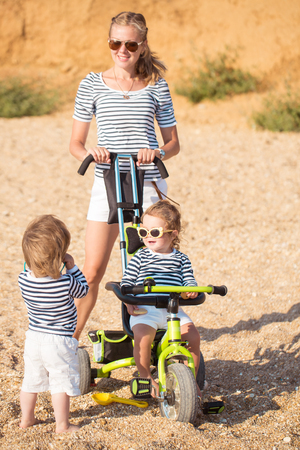 Mother playing with children on the beachの写真素材