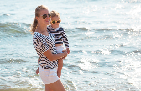 Mother playing with daughter on the beachの写真素材