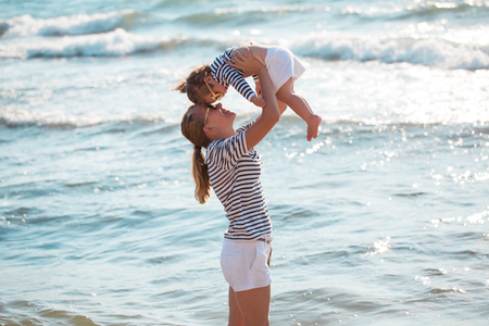 Mother playing with daughter on the beachの写真素材
