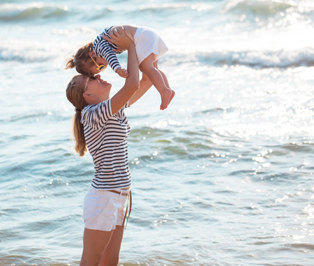 Mother playing with daughter on the beachの写真素材