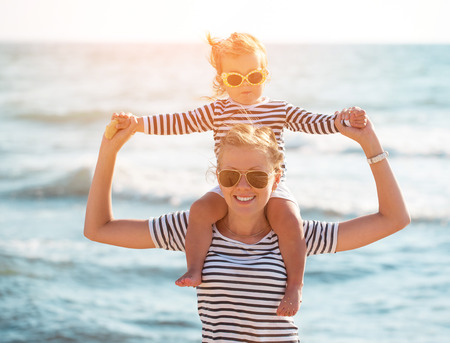 Mother playing with daughter on the beachの写真素材