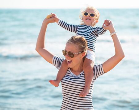 Mother playing with daughter on the beachの写真素材