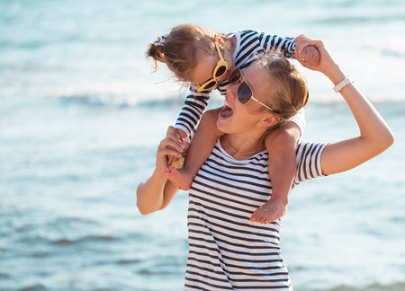 Mother playing with daughter on the beachの写真素材