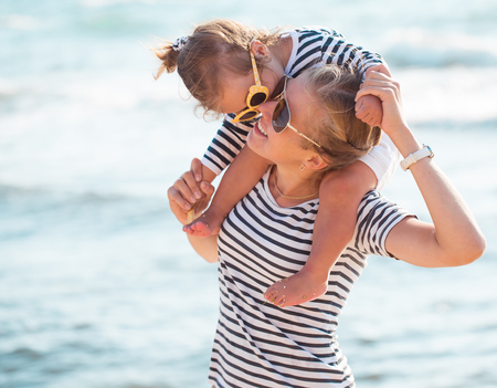 Mother playing with daughter on the beachの写真素材