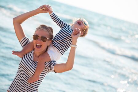 Mother playing with daughter on the beachの写真素材