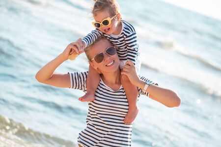 Mother playing with daughter on the beachの写真素材