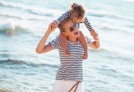 Mother playing with daughter on the beachの写真素材