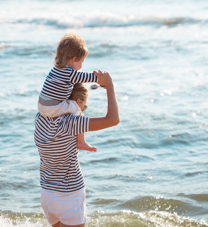 Mother playing with son on the beachの写真素材