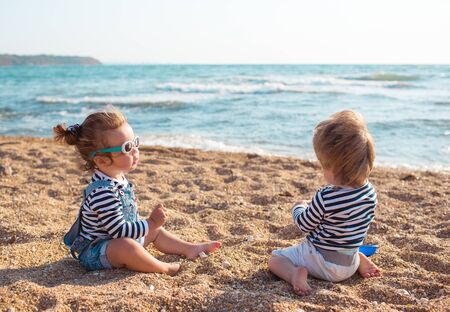 Little boy and girl playing on the beachの写真素材