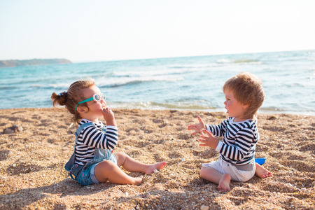 Little boy and girl playing on the beachの写真素材