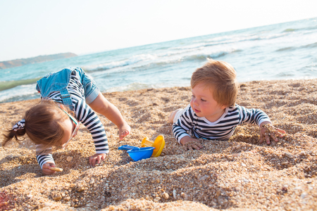 Little boy and girl playing on the beachの写真素材