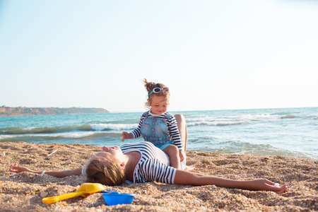 Mother playing with daughter on the beachの写真素材