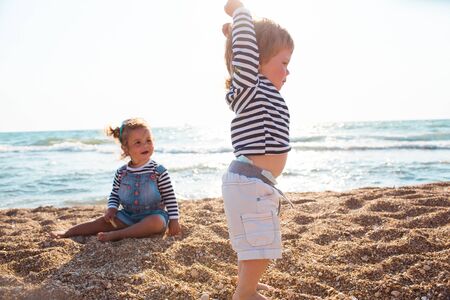 Little boy and girl playing on the beachの写真素材