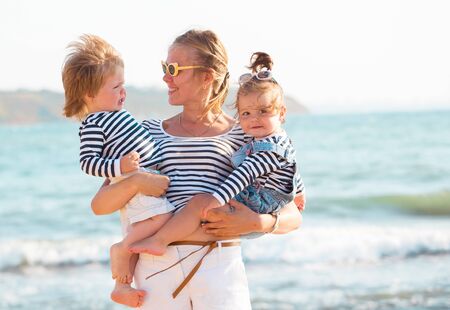 Mother playing with children on the beachの写真素材