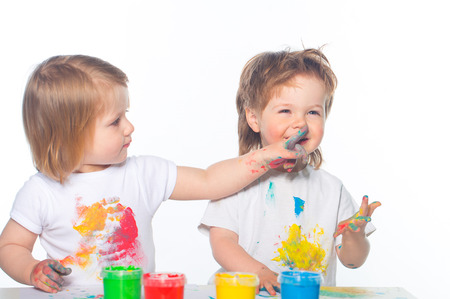 Little boy and girl playing with paintsの写真素材