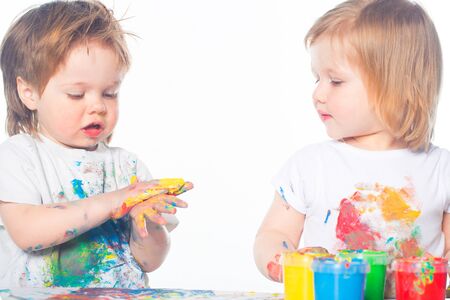Little boy and girl playing with paintsの写真素材