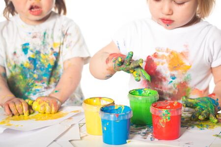 Little boy and girl playing with paintsの写真素材