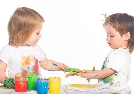 Little boy and girl playing with paintsの写真素材