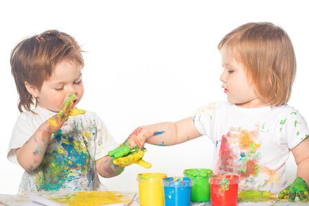 Little boy and girl playing with paintsの写真素材