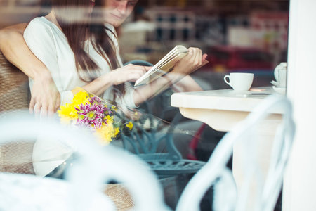 Happy young couple in cafe, having a great time together. View through cafe window.の写真素材