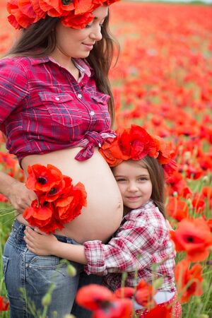 Happy family resting on the poppy fieldの写真素材