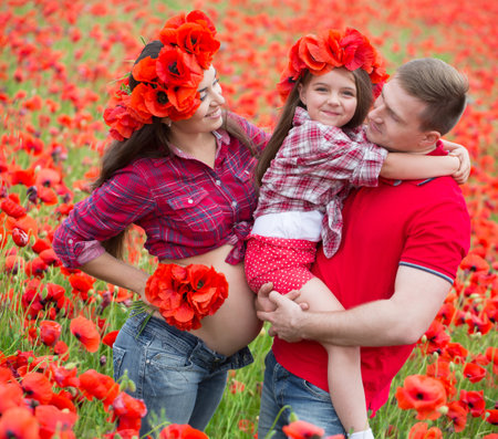 Happy family resting on the poppy fieldの写真素材