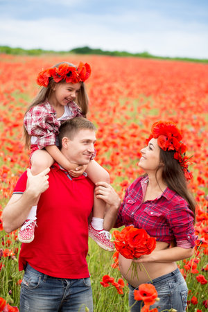 Happy family resting on the poppy fieldの写真素材