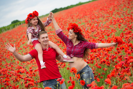 Happy family resting on the poppy fieldの写真素材