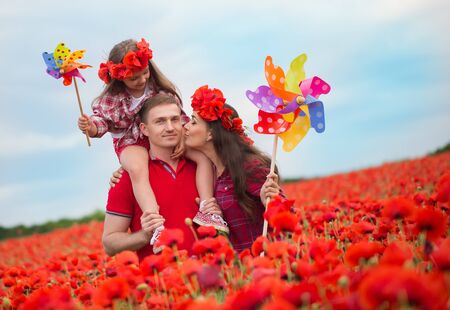 Happy family resting on the poppy fieldの写真素材