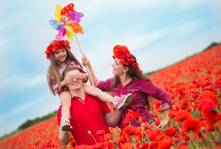 Happy family resting on the poppy fieldの写真素材