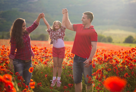 Happy family resting on the poppy fieldの写真素材