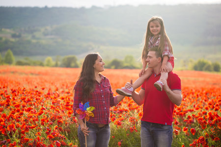 Happy family resting on the poppy fieldの写真素材