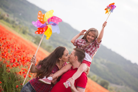 Happy family resting on the poppy fieldの写真素材