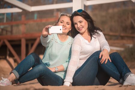 Young beautiful girls taking self photo by cellphoneの写真素材