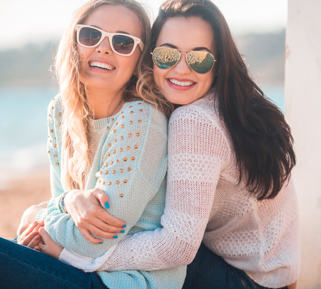 Two girls resting on the autumn beachの写真素材