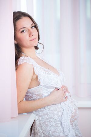 Pregnant woman portrait with tulip flowers  at home.の写真素材