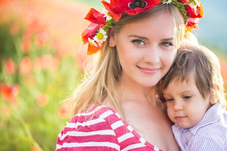 Mother playing with sonon poppy fieldの写真素材