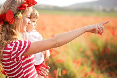 Mother playing with sonon poppy fieldの写真素材