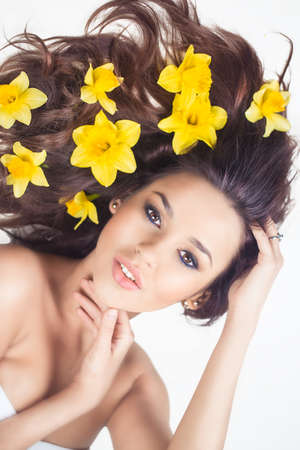 Beautiful woman with flowers in hair, isolated on white.の写真素材