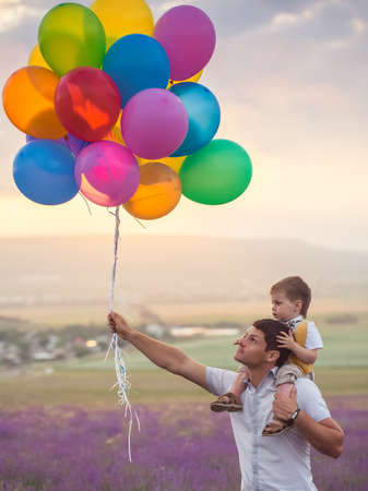 Father with son playing on lavender fieldの写真素材
