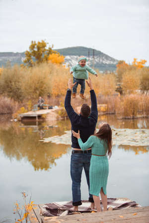 Young family resting on the lake shoreの写真素材