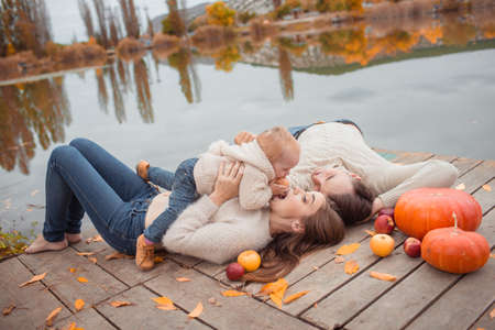 Young family resting on the lake shoreの写真素材