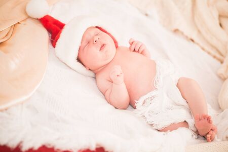 Infant boy in Santa hat laying on the bedの写真素材