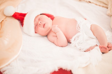 Infant boy in Santa hat laying on the bedの写真素材